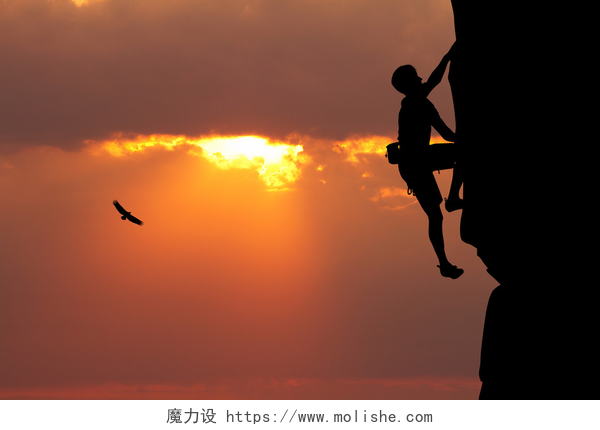 日落时分一个男人攀登的剪影爬山